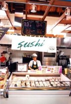 Employee behind sushi counter at grocery store