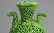 green plastic vase or urn with complex geometric striations all over the surface.